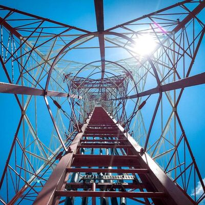 Torre de acero angular de 4 patas diseñada para cumplir con los estándares ANSI TIA y EN, que ofrece soporte para proyectos de infraestructura de telecomunicaciones y energía